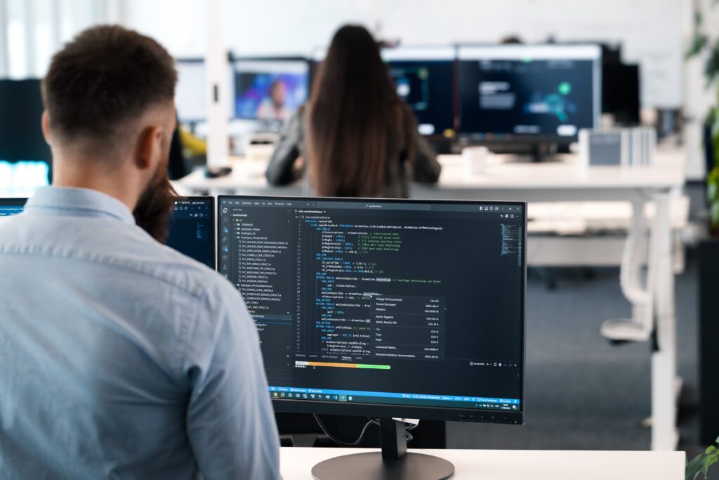 Automation enegineering working at a desktop computer to code actions on the shopfloor